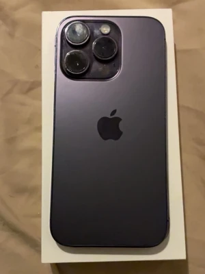 iPhone 14 Pro - Snygg iPhone 14 Pro i mörk färg. Mobilen har trippelkamera och ser ut att vara i gott skick, dock syns mindre repor på skärmen och kameralinserna. Perfekt för dig som vill ha en kraftfull och modern smartphone med avancerad kamera. Med 256 gb
