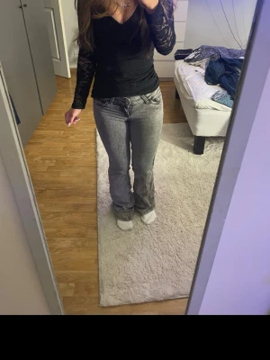 Grå lågmidjade bootcut jeans  - Lågmidjade grå bootcut jeans med detaljer på bakfickorna från Nelly. Säljer eftersom de inte har kommit till användning men har använts fåtal gånger, skriv för fler detaljer/ bilder💕 pris kan diskuteras! 