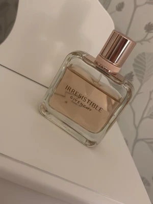Givenchy Irresistible parfym 50 ml  - Upptäck Givenchy Irresistible – en elegant parfym i stilren flaska med roségulddetaljer. Perfekt för dig som vill sticka ut och känna dig unik. Passar dig som gillar exklusiva märken och modern design.