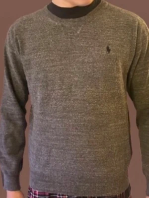 Grå stickad tröja från Polo Ralph Lauren - Säljer en stilren grå stickad tröja från Polo Ralph Lauren. Perfekt till lager-på-lager och enkel att matcha. Postar inom 24h!📦