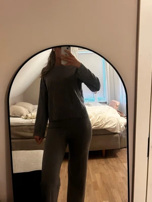 Mjuk grå loungewear-set - Säljer ett mysigt loungewear-set i mjuk grå färg. Setet består av en långärmad tröja med avslappnad passform och matchande byxor med raka ben. Perfekt för chill dagar hemma eller när du vill vara bekväm men ändå snygg.