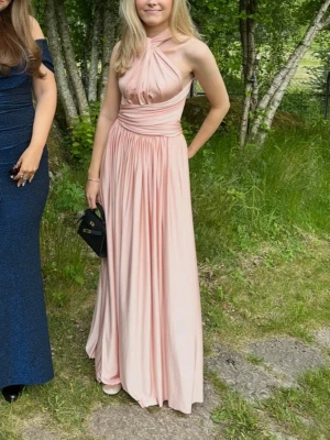 Ljusrosa balklänning - Säljer en ljusrosa balklänning från Eliza and Ethan som kan knytas på olika sätt. På deras hemsida kan man hitta flera olika knytningsalternativ. Klänningen är one size men den är insydd i midjan vilken inte syns vid använding och de passar mig som bär S. Materialet är mjukt och känns lyxigt. Klänningen har lite täcken på användning de är bara att säga till om man vill se bilder.🩷👗