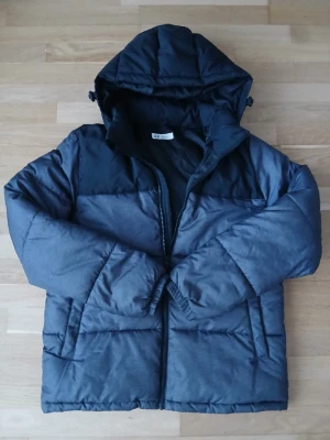H&M vinterjacka med huva strl. 164 - H&M vinterjacka strl. 164  Det finns ett litet fel på den högra ärmen (se foto).