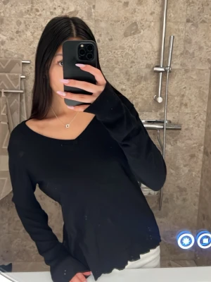 Svart v-ringad stickad tröja - En svart stickad tröja med  v-ringning, ribbad längst ner och vid ärmarna. Tröjan är i lite tunnare material och känns lite grövre än vanligt. På ärmarna är de små små hål. Dom syns om man drar ut tyget annars inget man lägger märke till. Lappen är bortklippt men skulle säga att den sitter som XS/S! Skriv privat för fler bilder eller funderingar