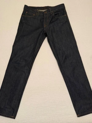 Nudie jeans, Gritty Jackson Dry Old - Säljer ett par Nudie Gritty Jackson i storlek 32/32 och i dry old, vilket innebär att dem åldras och ändrar färg/tvätt/fade med tiden, i enlighet med bild 4. Dem lär få fade snabbt iom att dem inte är så tjocka! Perfekt för den som vill skapa sina egna unika jeans. Nypris ca 1600. Pris går att diskutera.