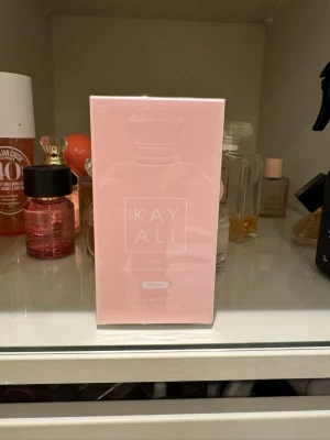 Kayali - Marsmellow  - Kayali Yum är en parfym i en snygg ljusrosa förpackning med minimalistisk design. Flaskan rymmer 100 ml och har en feminin, modern look. Perfekt för dig som gillar söta och fräscha dofter med en lyxig känsla.