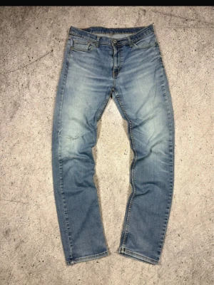 Levis vintage  - Säljer ett par ljusblå jeans med rak passform och snygga slitningar på låret. Levis jeansen är sällsynta och i bra modell så därav priset samt så är dem i väldigt bra skick 