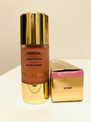 Hourglass Unreal Liquid Blush Scene - Hourglass Unreal Liquid Blush i nyansen Scene. Flytande rouge i en lyxig glasflaska med guldfärgat lock och detaljer. Färgen är en mjuk rosa ton som ger en naturlig glow till kinderna. Kommer i originalförpackning med matchande design.