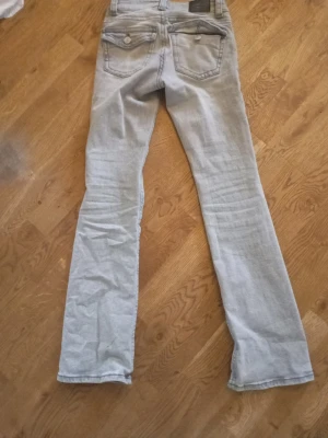Ljusgrå low waist  bootcut jeans  Gina Tricot - Snygga ljusgrå jeans från Perfect Jeans i klassisk bootcut-modell. Jeansen har fem fickor, bälteshällor och en stilren look som passar till det mesta. Tillverkade jeanstyg för en bekväm känsla hela dagen.