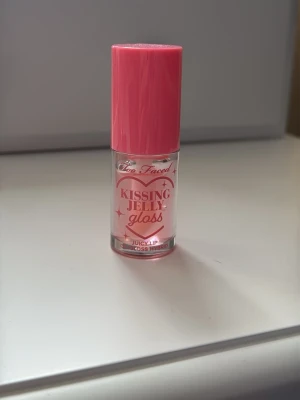 Too Faced Kissing Jelly Gloss Pink - Säljer ett Too Faced Kissing Jelly Gloss i färgen Pink Sherbet. Helt oanvänd! Läppglanset är en hybrid mellan gloss och lip oil, kommer i en söt cylinderformad tub med rosa lock och transparent behållare. Innehåller 4,5 ml och ger en glansig finish med hint av rosa.