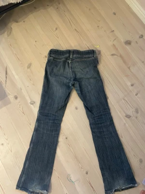 Blå bootcut jeans med fickor - Säljer ett par jätte snygga jeans har lite hål längst ner på byxan 