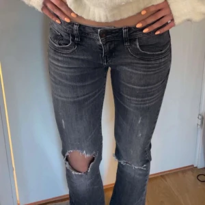LTB JEANS - Säljer ett par grå bootcut jeans med slitningar och hål vid knäna. Jeansen har fem fickor, knapp och dragkedja framtill samt klassiska sömmar. Perfekta för en avslappnad och trendig look.