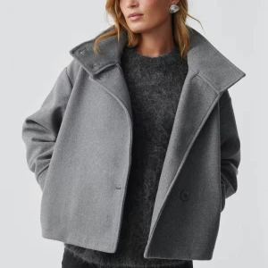 Grå kappa med krage - Säljer den slutsålda kappan från Ginatricot i kort och oversized fit. Supersnygg, men är missnöjd med färgen för min smak. Storlek S