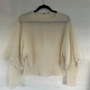 Krämvit blus med ballongärmar - Säljer en krämvit blus med snyggt strukturerat tyg och ballongärmar. Blusen har rund halsringning och långa ärmar som smalnar av vid handlederna. Perfekt för dig som gillar en stilren men ändå unik look.🤩💕