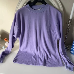 Ljuslila långärmad tröja vintage - Ljuslila långärmad tröja från Super Sweden med klassisk rund halsringning. Tröjan är i mjuk bomull och har en enkel, clean look utan mönster eller tryck. Perfekt för dig som gillar en stilren och chill vibe.
