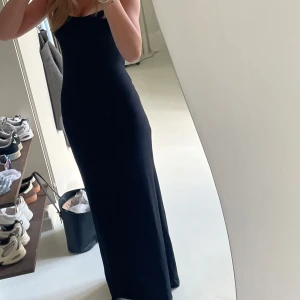 Svart långklänning med smala axelband - Säljer en svart långklänning med smala axelband och figurnära passform. Klänningen har en enkel och stilren design som framhäver siluetten. Perfekt för dig som gillar minimalistisk stil och vill ha en klänning som känns både cool och elegant köpt från gina. Nypris: 300 knappt använd. Xxs