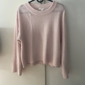 Ljusrosa stickad tröja Gina Tricot - Supermysig ljusrosa stickad tröja från Gina Tricot med bred ribbad kant vid hals, ärmslut och nederkant. Tröjan har en relaxed fit och är perfekt för kyliga dagar. Enkel att matcha med jeans eller kjol för en chill look.