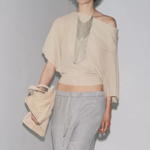 Beige offshoulder tröja från Zara - Säljer en beige offshoulder tröja från Zara med lös passform och korta, vida ärmar. Tröjan har en asymmetrisk halsringning och är tillverkad i ett tunt, stickat material som känns luftigt och skönt. Perfekt för dig som gillar en chill och trendig vibe. Har en mindre defekt på ärmen men inget som märks Skriv för mer info om det. Är villig att diskutera pris 