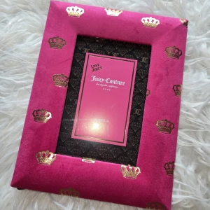 Juicy Couture Home Fotoram 4x6 tum - Elegant fotoram från Juicy Couture i rosa sammet med guldfärgade kronor. Passar bilder i storlek 4x6 tum. Perfekt för att ge ditt hem en lyxig touch. Ramen är i mycket fint skick utan synligt slitage.
