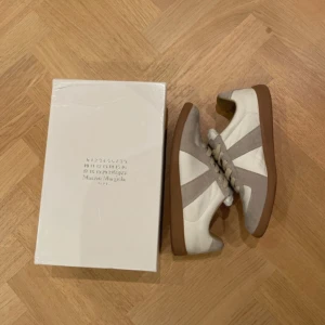 Maison Margiela sneakers - Säljer ett par riktigt schyssta maison margiela sneakers. Skorna är i bra använt skick. Skolådan medföljer men är lite skadad, som syns på bilderna. Hör gärna av er för fler bilder eller funderingar😇