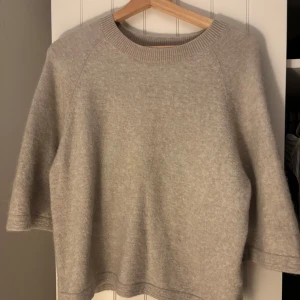 Beige stickad tröja i alpackaull - Mysig beige stickad tröja med rund hals och trekvartsärm. Tillverkad i en lyxig blandning av 52% ull och 45% alpacka, från other stories 
