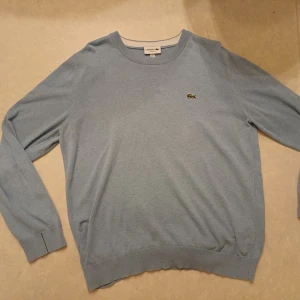 Ljusblå stickad tröja från Lacoste - Sparsamt använt, passar storlek L,  skriv vid frågor 