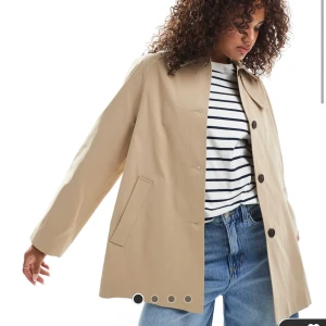 Beige trenchcoat med knappar - Medellång kappa från ASOS. Helt ny med prislapp kvar. Säljer pga att tiden för att returnera gått ut (därav säljer jag i två olika storlekar). Nypris 859 kr! 