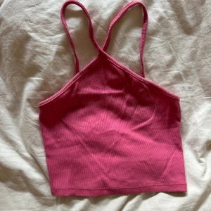 Rosa ribbad linnetopp med smala band - Säljer en rosa ribbad linnetopp från Zara med smala axelband som korsas fram till. Toppen är croppad och har en enkel, stilren design som passar perfekt till jeans eller kjol. Materialet är mjukt och stretchigt för en bekväm passform.❤️🥰