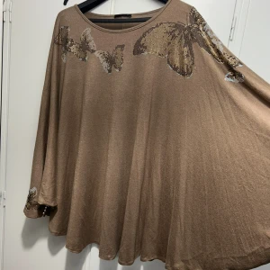 Beige oversized tröja med paljettfjärilar - Säljer en beige oversized tröja från You med glittriga paljettfjärilar framtill och på ärmarna. Tröjan har rund halsringning och vida, långa ärmar. Materialet är mjukt och faller snyggt. Perfekt för dig som gillar statement-detaljer och bekväm passform.