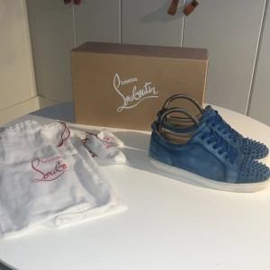Blå mocka sneakers Christian Louboutin - Hej! Säljer ett par !ÄKTA¡ Christian Louboutin, skorna är i  jättebra skick och mockan håller jättebra. Nya ÄKTA sulor från Christina Louboutin då de gamla började bli lite slitna. (Gamla finns kvar) Låda, extra snören, spikar och alla dustbags finns. Strlk 41 men passar 42 utan problem. Om det är några funderingar fråga bara! 
