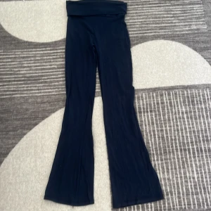 Mörkblå bootcut byxor 146/152 - Snygga mörkblå byxor med bootcut-modell och hög midja. Mjukt och stretchigt material som sitter skönt och ger en avslappnad vibe. Perfekta för dig som gillar en trendig och bekväm stil.