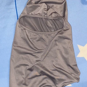 Grå skimask under vintertider  - Snygg grå mask under vintertider där de kan bli kallt om ansiktet. Tillverkad i ett mjukt och stretchigt material som sitter bekvämt. Perfekt för kalla väder 