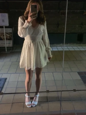 Vit Klänning  - Färg: Vit  Mönster: Små prickar, spets  Storlek: 34/XS  Märke: SHEIN   Klänningen har ett resårband vid midjan som ger en snygg passform på din figur! Användes en gång till min konfirmation! 🤍🕊️  