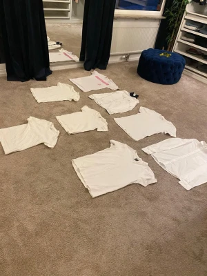 8 vita t-shirts i olika modeller - Säljer ett paket med åtta vita t-shirts i olika modeller och passform. Några har tryck, andra är helt vita. Perfekta basplagg till garderoben och enkla att matcha. Alla är kortärmade och i klassisk t-shirtmodell.