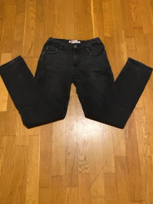 Svarta Levis 511 jeans straight fit - Säljer ett par svarta Levis 511 jeans med klassisk femficksdesign och raka ben. Jeansen har normal midja och är tillverkade i mjukt bomullsmaterial med lite stretch för extra komfort. Perfekta till en avslappnad streetstyle-look.