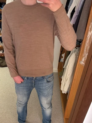 Beige stickad tröja från Uniqlo - Säljer en stilren beige stickad tröja från Uniqlo i storlek XS. Tröjan har rund halsringning, långa ärmar och ribbade muddar vid ärmslut och nederkant. Passar 160/170. Perfekt för lager på lager och enkel att matcha med jeans eller chinos.
