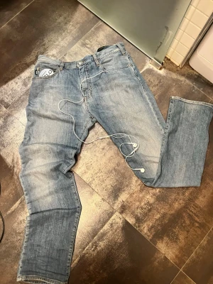 Slim fit Armani Jeans - ÄKTA sköna ljusblåa Armani jeans med rak passform och bra tvätt för de som gillar archive. Original bris 2500kr och är tillverkade i slitstark bomullsdenim. Perfekta för en avslappnad och tidlös stil. Säljer pga för små