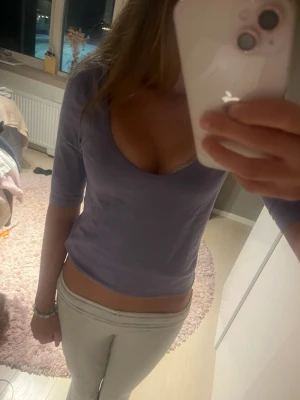 Ljuslila croppad topp med v-ringning - Säljer en ljuslila croppad topp med v-ringning och halvlånga ärmar. Toppen har en enkel och stilren design som passar perfekt till jeans eller kjol. Materialet känns mjukt och stretchigt, vilket gör den bekväm att bära. Storlek S