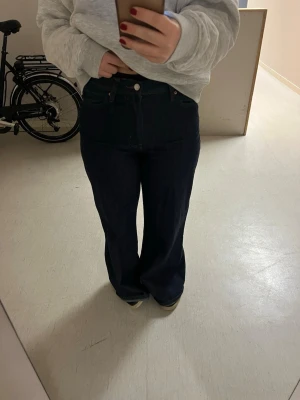 High wide jeans  - Säljer ett par mörkblå jeans med hög midja och wida ben. Jeansen har klassisk femficksdesign och stängs med knapp och dragkedja. Perfekta till en avslappnad och trendig look. Använda två gånger ☺️