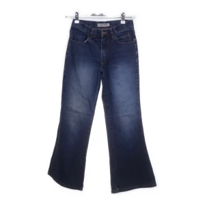 Bootcut jeans från D-XEL - Snygga blå bootcut jeans från D-XEL. Jeansen har en mörk tvätt och breda ben som ger en retrovibe. Perfekta för dig som gillar en avslappnad men trendig look.