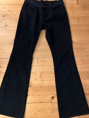Svarta bootcut jeans - Snygga svarta jeans med bootcut passform och klassisk femficksdesign. Köpta på sellpy men säljer här pågrund av för små. Innerbenslängd ca: 78 cm. Midjemått ca: 38 cm 