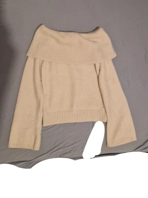 Beige offshoulder stickad tröja SHEIN - Superfin beige stickad tröja från SHEIN i offshoulder-modell. Tröjan har bred ribbad kant upptill och vid ärmslut samt en croppad passform. Perfekt för dig som vill ha en mysig men ändå stylish look.
