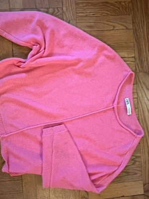 Rosa kofta från Zara - Mysig rosa kofta från Zara i mjukt stickat material. Koftan har en avslappnad passform, långa ärmar och ribbade muddar vid ärmslut och nederkant. Perfekt att slänga över en t-shirt för en chill look.