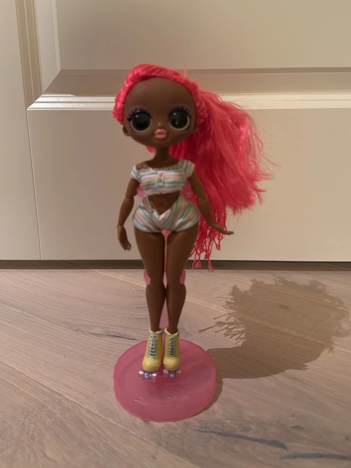 Docka med rosa hår och rullskridskor