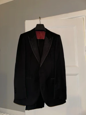 Smoking från Suitsupply + Smokingskjorta - Väldigt sparsamt använd. Kavaj modell Lazio Tuxedo FL Slim storlek 46 (s). Byxor modell Brescia storlek 23 (s). Skjorta storlek 37 (small), medföljande knappar (ej manschetter). Galge och travel bag inkluderat.
