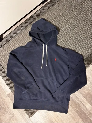 Ralph Lauren hoodie - Ralph Lauren hoodie _______________________________________________  - Size M - Medföljer inget. - Matrinblå - Mycket fint skick (9/10) _______________________________________________  - Nypris 2 400kr  - Vårt pris 799 _______________________________________________  För fler frågor kan ni höra av er i PM.