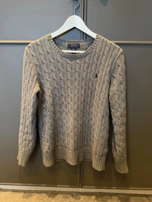Polo Ralph Lauren tröja - Riktigt snygg kabelstickad från Polo Ralph Lauren. Den är i mycket bra skick och har storleken 14-16 år vilket ungefär motsvarar XS-S. Nypris är väldigt högt, jag anser att 550 är ett bra pris för denna tröja!