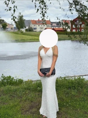 Balklänning - Balklänning från Dressroom Linné med släp, nypris 5000kr. Fint skick, passar både xs och S då banden är ställbara. Vit glittrig, öppen i ryggen