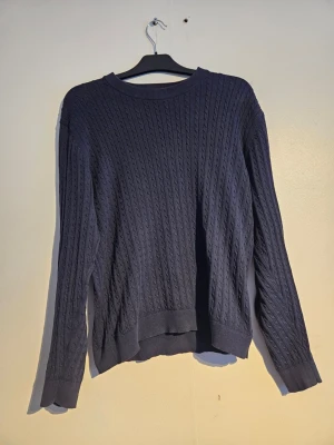 Mörkblå kabelstickad tröja - Säljer en mörkblå kabelstickad tröja med rund hals och långa ärmar. Selected homme.