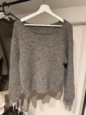 Brun stickad tröja från Vila - Mysig stickad tröja från Vila i storlek S. Tröjan har en rund halsringning och långa ärmar. Den är fluffig och mjuk, perfekt för kyliga dagar. Passformen är normal och materialet känns varmt och skönt.